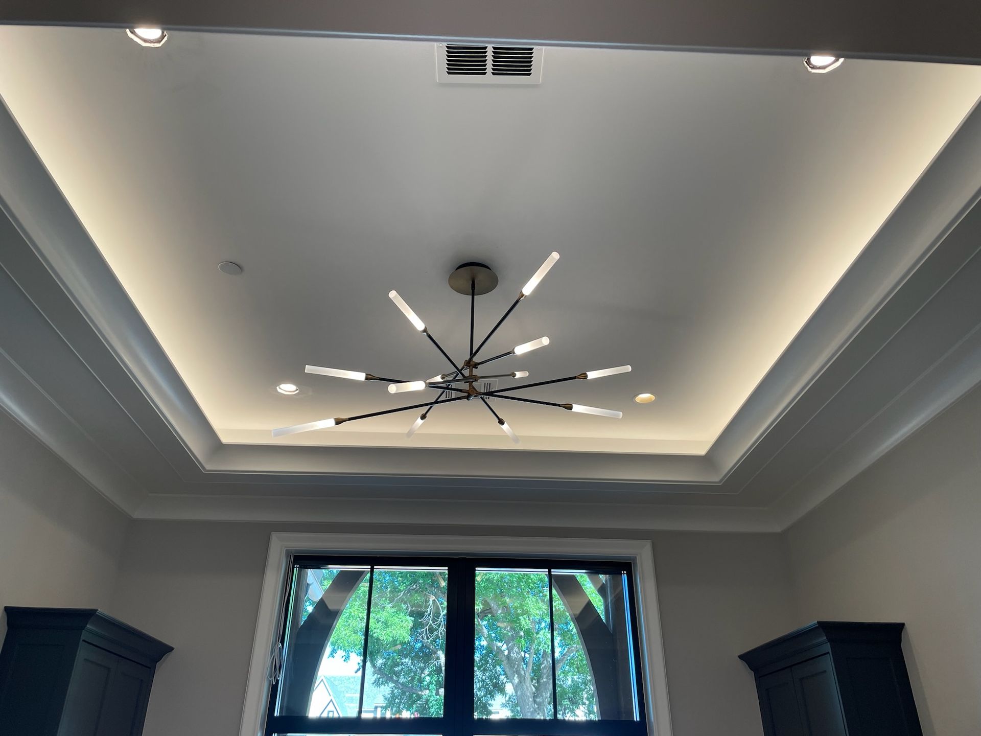 A ceiling fan is hanging from the ceiling of a room with a window.   
