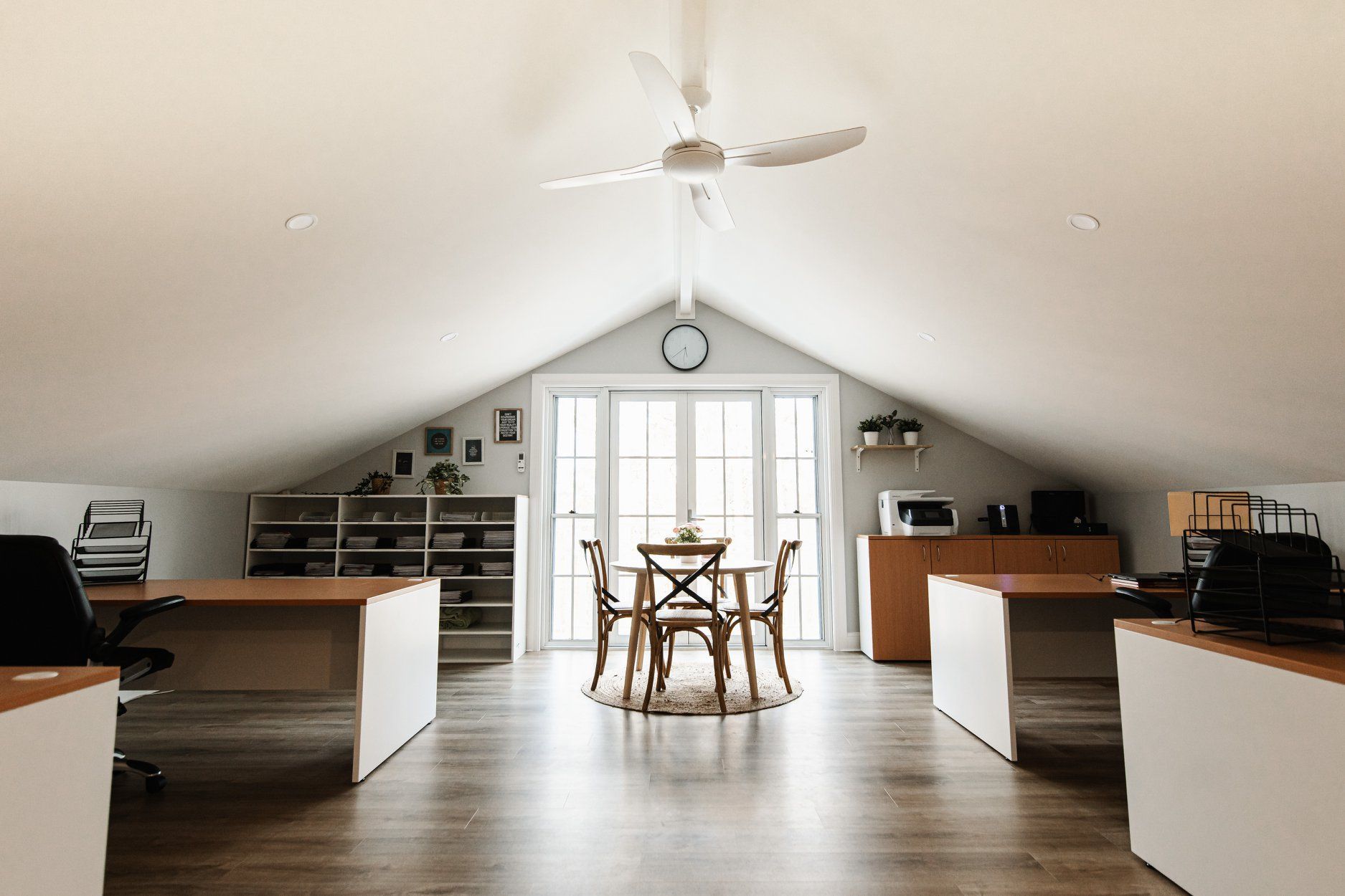 A sunlit attic office with white slanted walls, a wood-floored workspace with desks, and a central table and chair set. — Michael Duncan Constructions Pty Ltd in Mermaid Beach, QLD