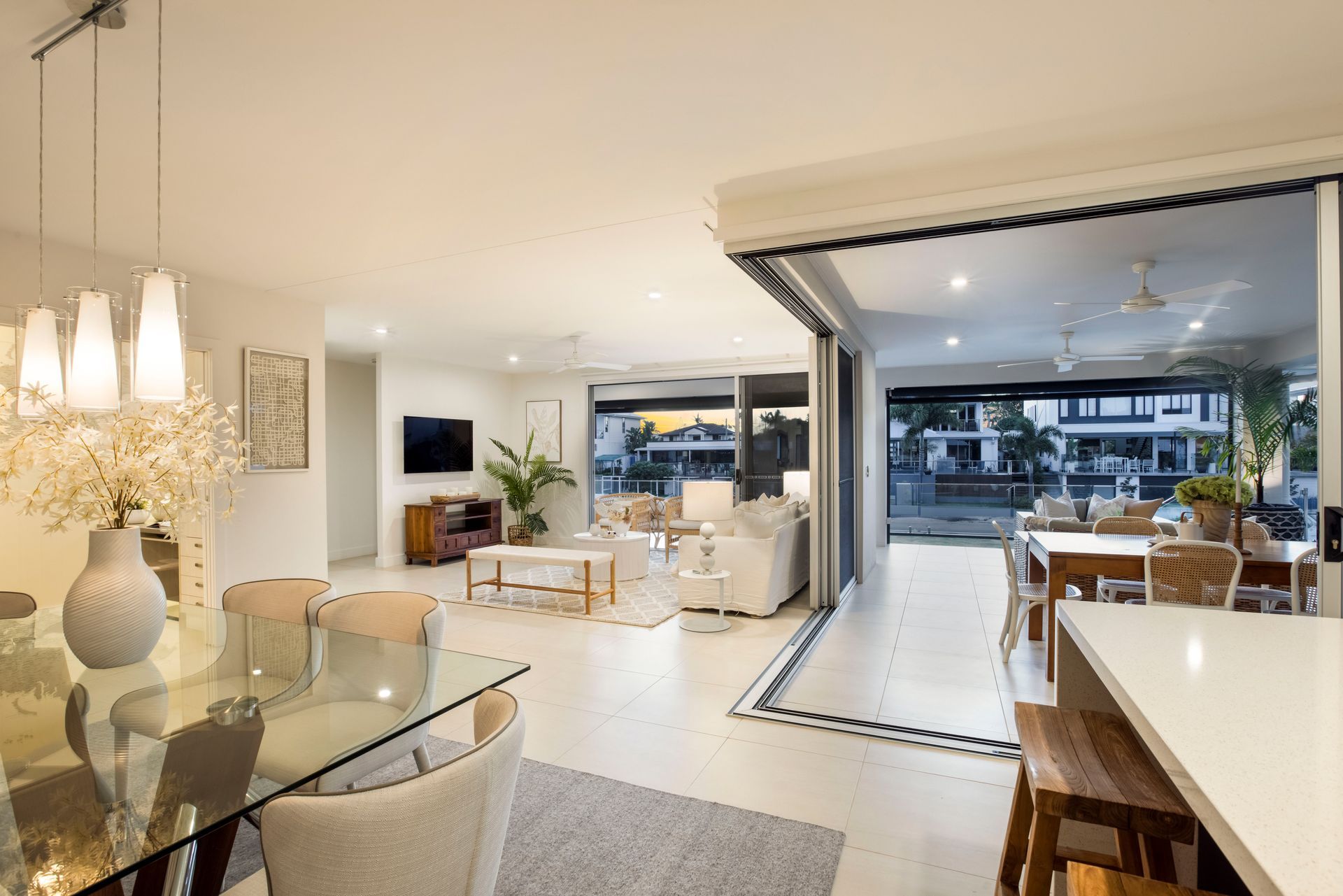 An Open-concept Living Area With a Glass Dining Table — Michael Duncan Constructions Pty Ltd in Robina, QLD