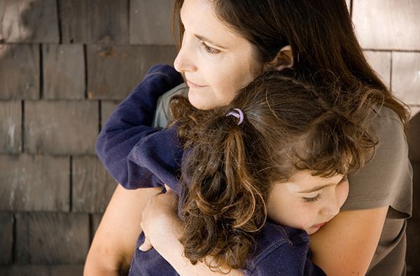 a woman is holding a little girl in her arms .