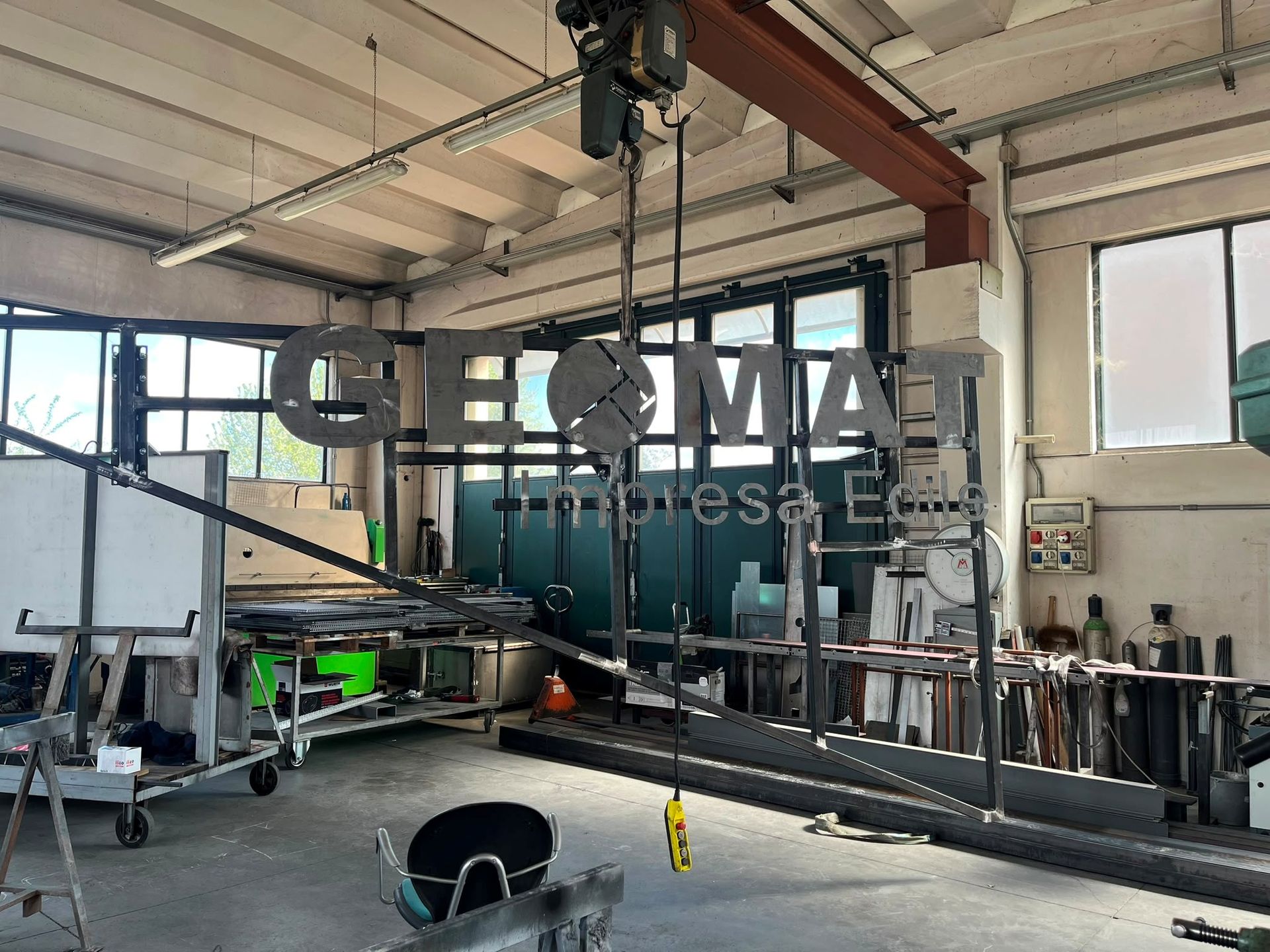 Officina industriale con grandi macchinari e utensili in metallo all'interno di un magazzino luminoso.