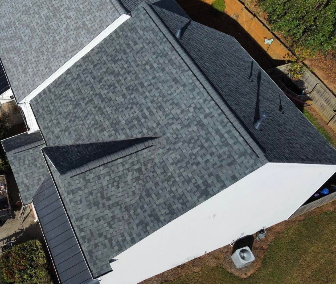 Overhead view of a house with a gray shingle roof and white exterior walls.