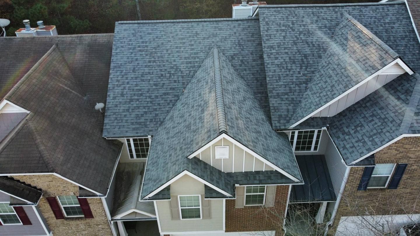 Overhead view of a suburban home with a gray roof and tan siding.