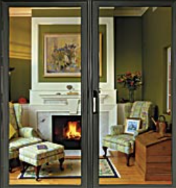 Cozy living room with fireplace, two armchairs, and framed artwork, seen through a glass door