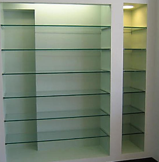 Empty wall-mounted glass display shelves in a light-colored room
