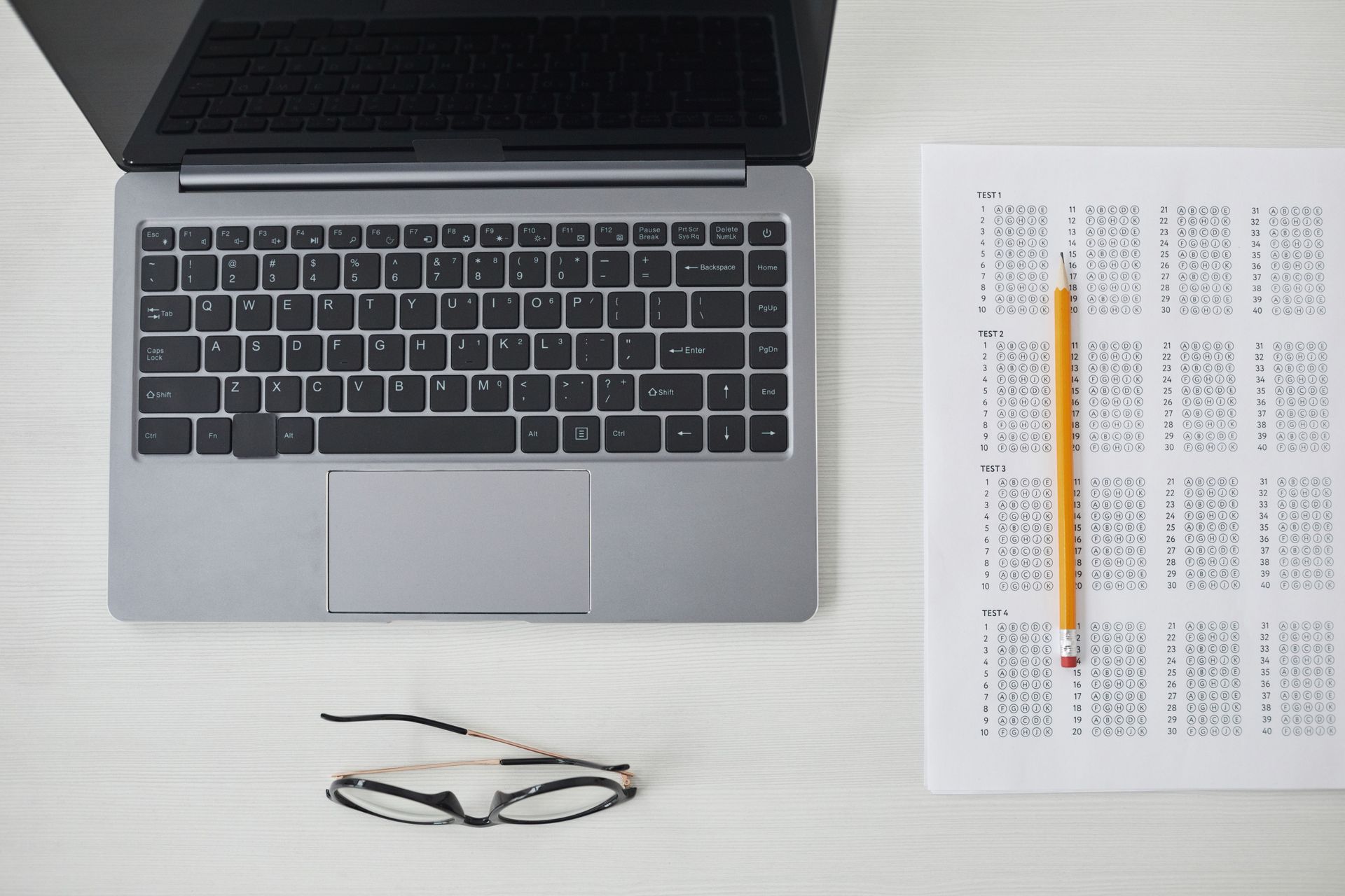 Hands typing on a laptop keyboard beside a document on screen