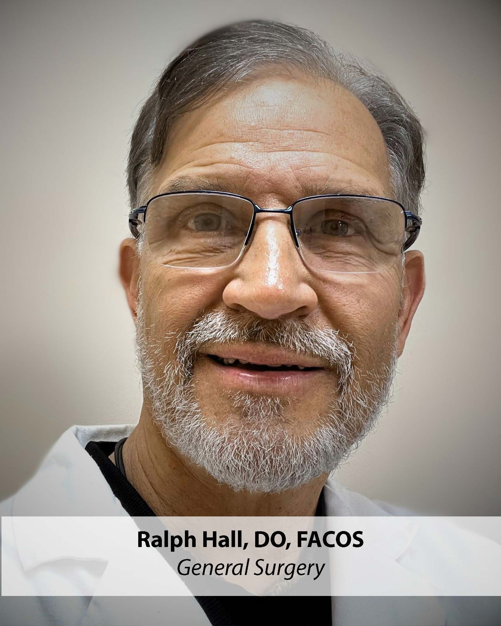 Ralph Hall, DO, FACOS, a general surgeon, wearing glasses and a white coat.
