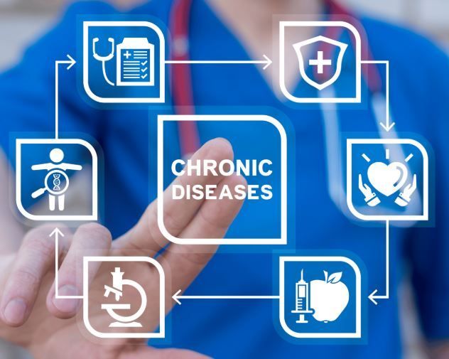 Doctor pointing at diagram of chronic diseases, with associated medical icons.
