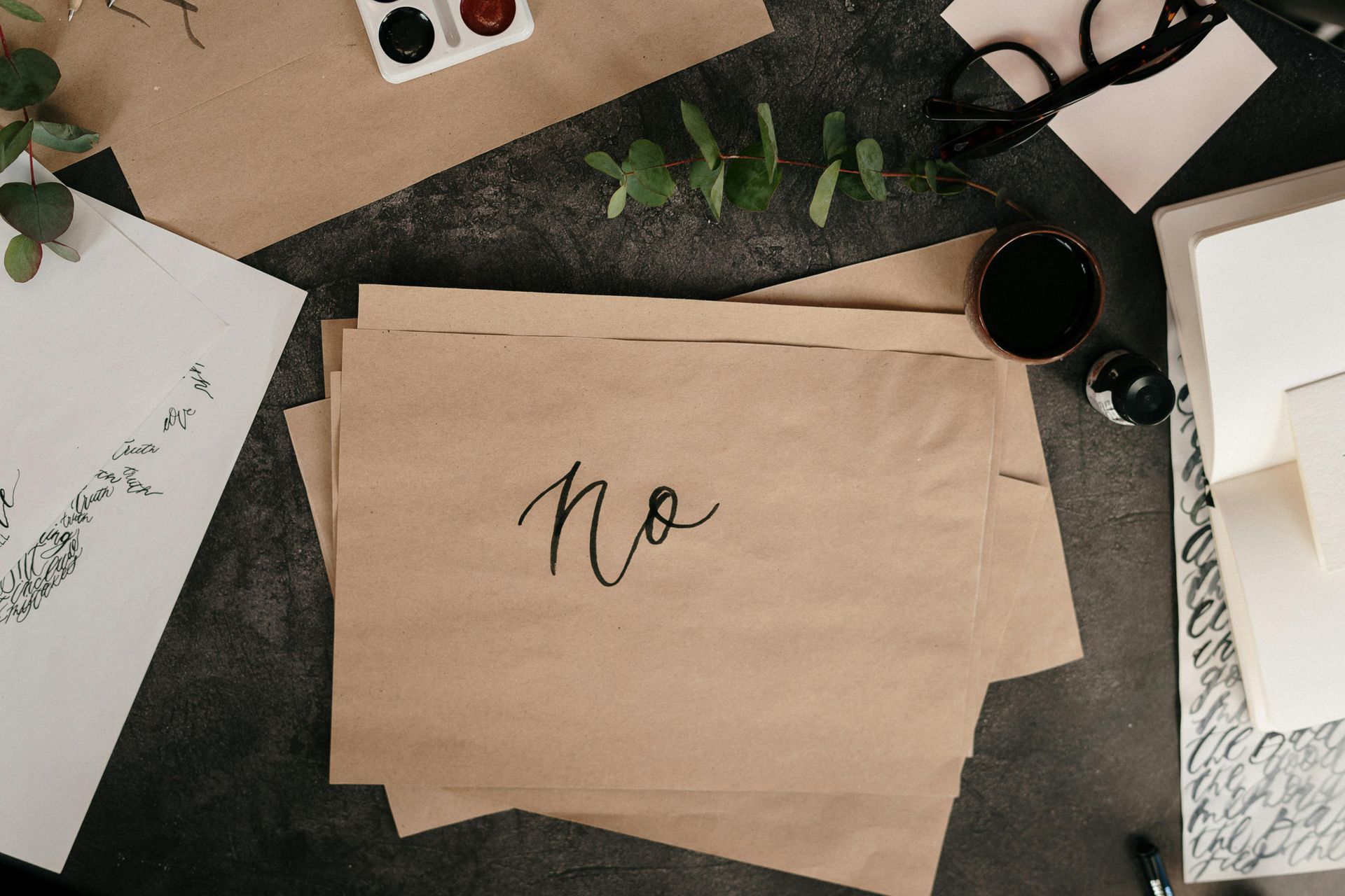 A stack of brown paper on a dark surface, with the word 