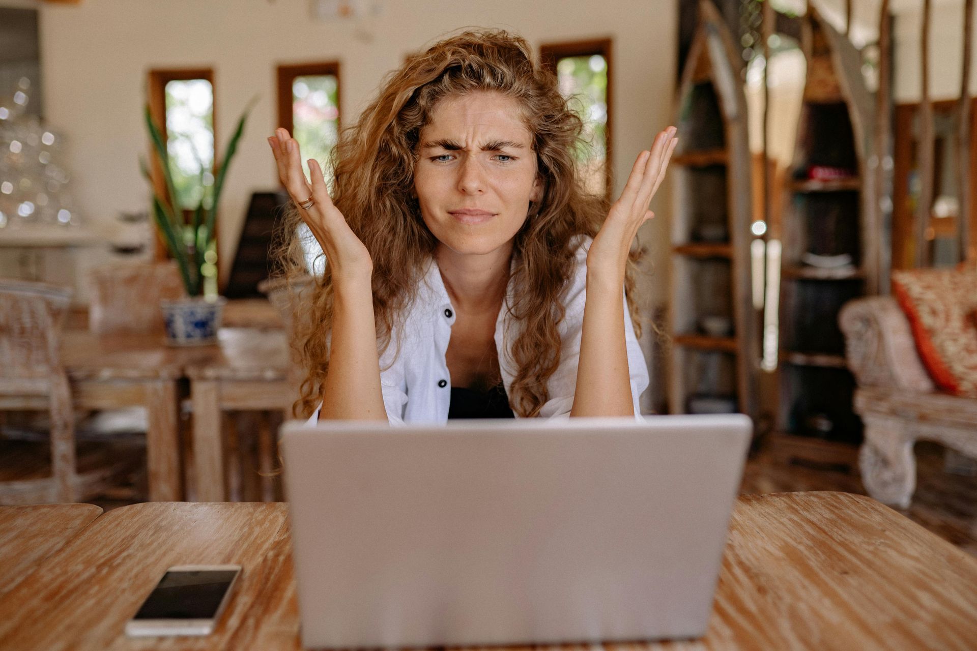 A woman is sitting at a table using a laptop computer.