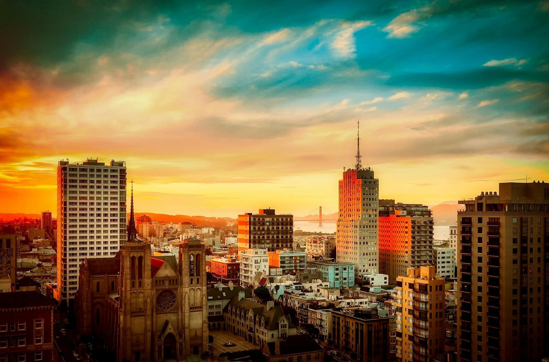 Golden sunset over a San Francisco cityscape featuring Grace Cathedral and downtown skyscrapers.