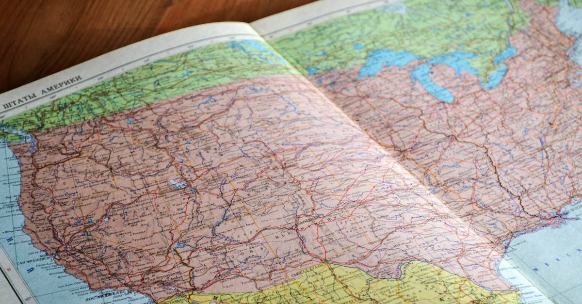 A map of the united states is open on a wooden table.