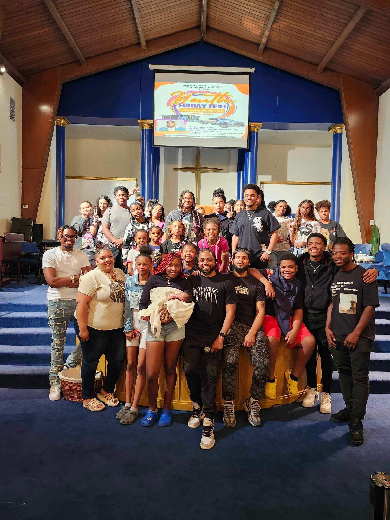 Group of people posing on a stage inside a church. A banner says “Summer Fun”