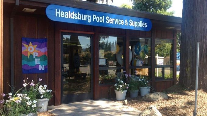 Storefront of Healdsburg Pool Service & Spas with glass doors, potted plants, and an open sign