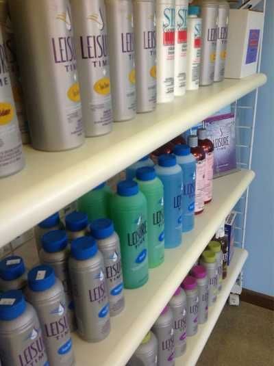 Shelves stocked with assorted bottled laundry detergent in a store aisle