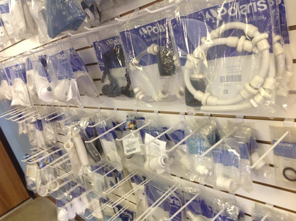Rows of packaged white cables and accessories hanging on a store display wall.