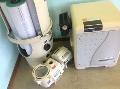 Vacuum cleaner parts and a beige upright vacuum on a carpeted floor