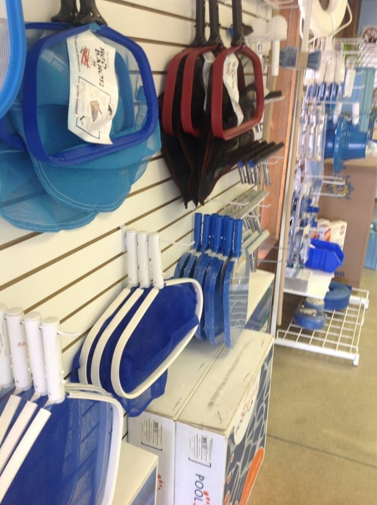 Blue and black lunch bags and pencil cases hanging on a store display rack