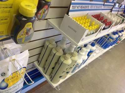 Store shelf with cleaning products and spray bottles in white and yellow packaging