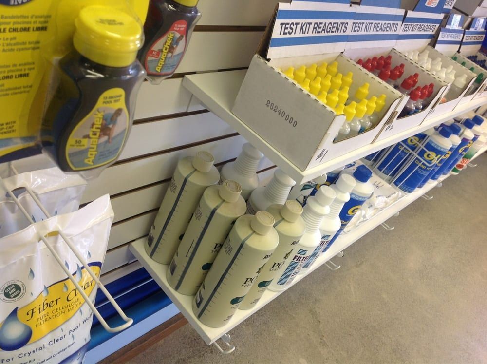 Store shelf with cleaning products and spray bottles, including yellow and blue items, in a retail aisle