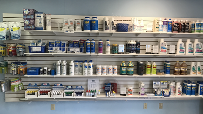 Shelves stocked with assorted paint cans and supplies in a hardware store aisle