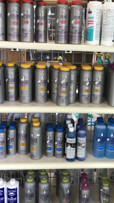 Shelves stocked with rows of aerosol spray cans and paint cans in assorted colors.