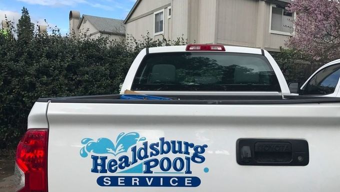 Healdsburg Pool Service logo on white pickup truck tailgate in residential driveway