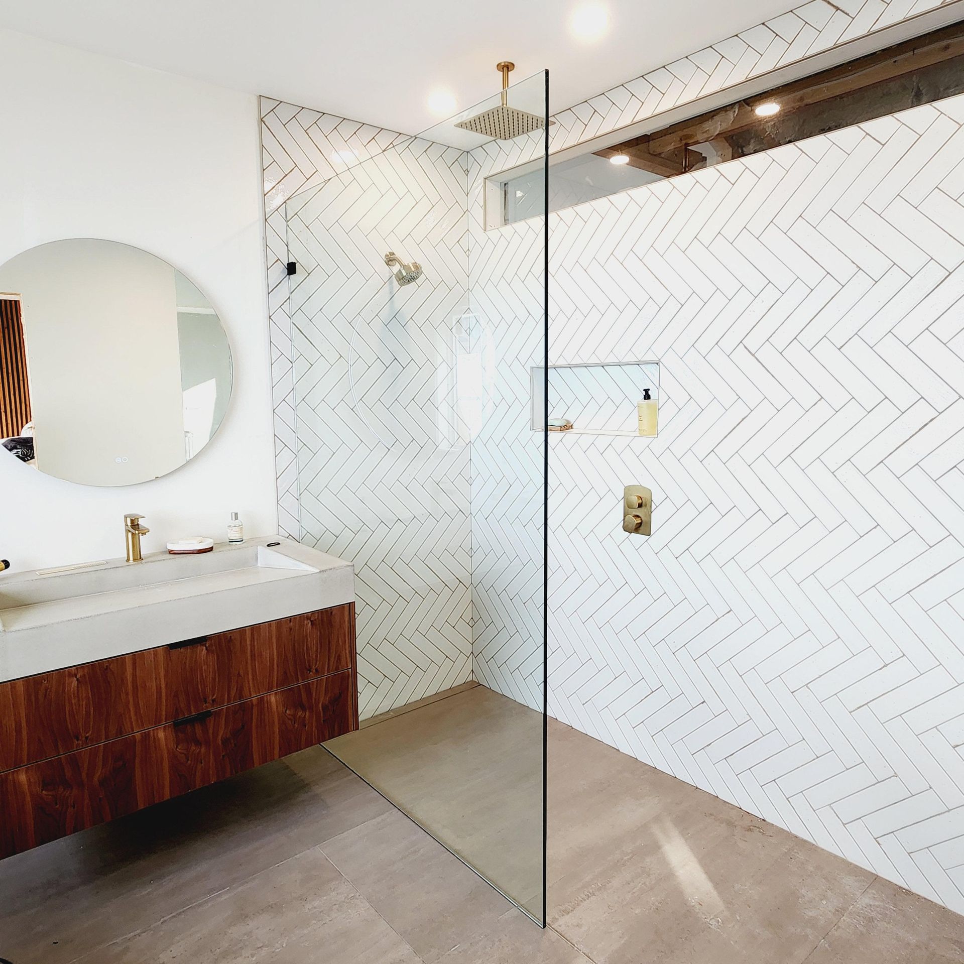 A bathroom with a walk in shower and a sink