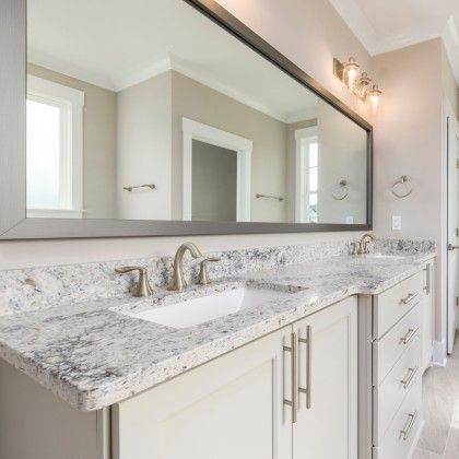 A bathroom with two sinks and a large mirror.