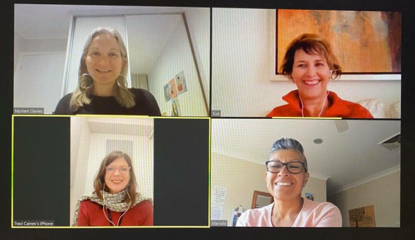 Four women are smiling on a video call on a computer screen.