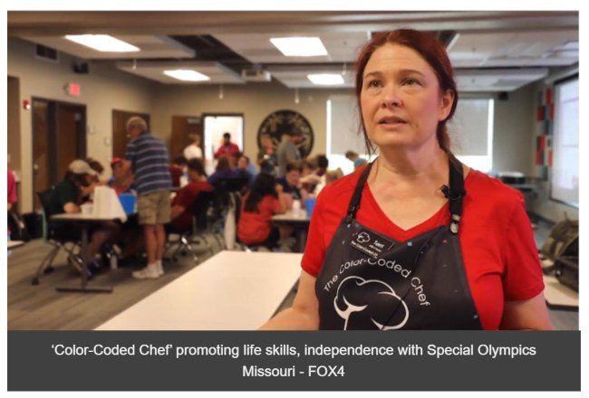 A woman in an apron is standing in a room