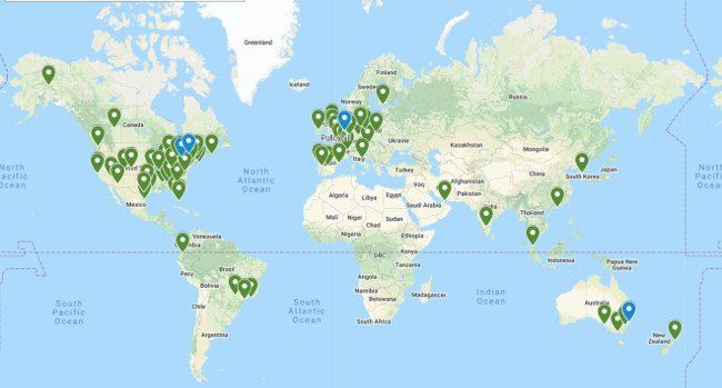 A map of the world with green pins on it.