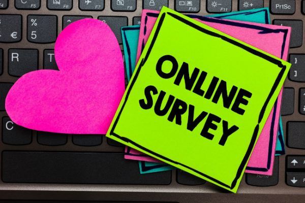Online Survey A sticky note on a keyboard that says online survey