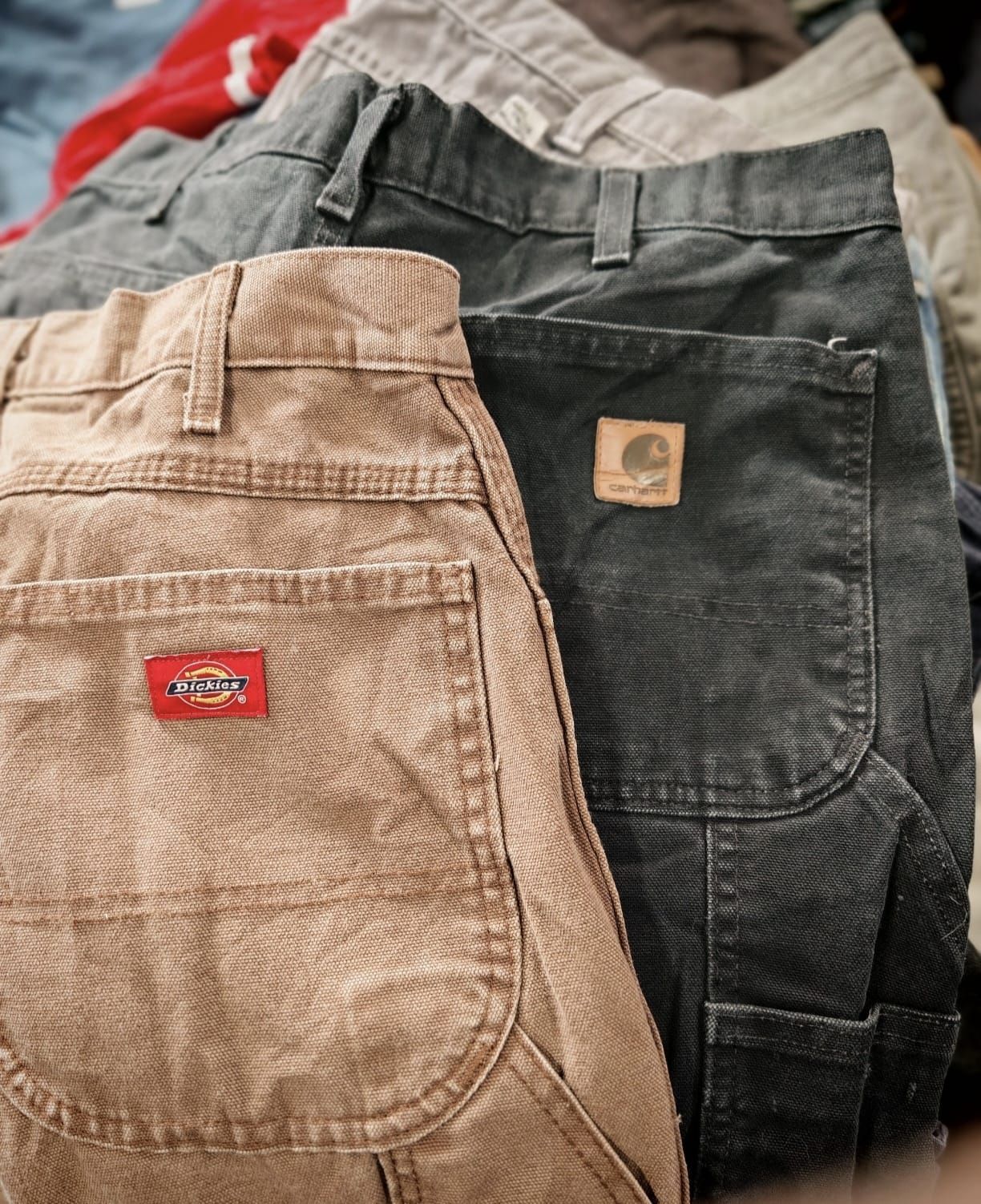 Pantaloni in velluto a coste sovrapposti nei colori beige, grigio scuro e bianco, con tasche posteriori a vista ed etichette del marchio.