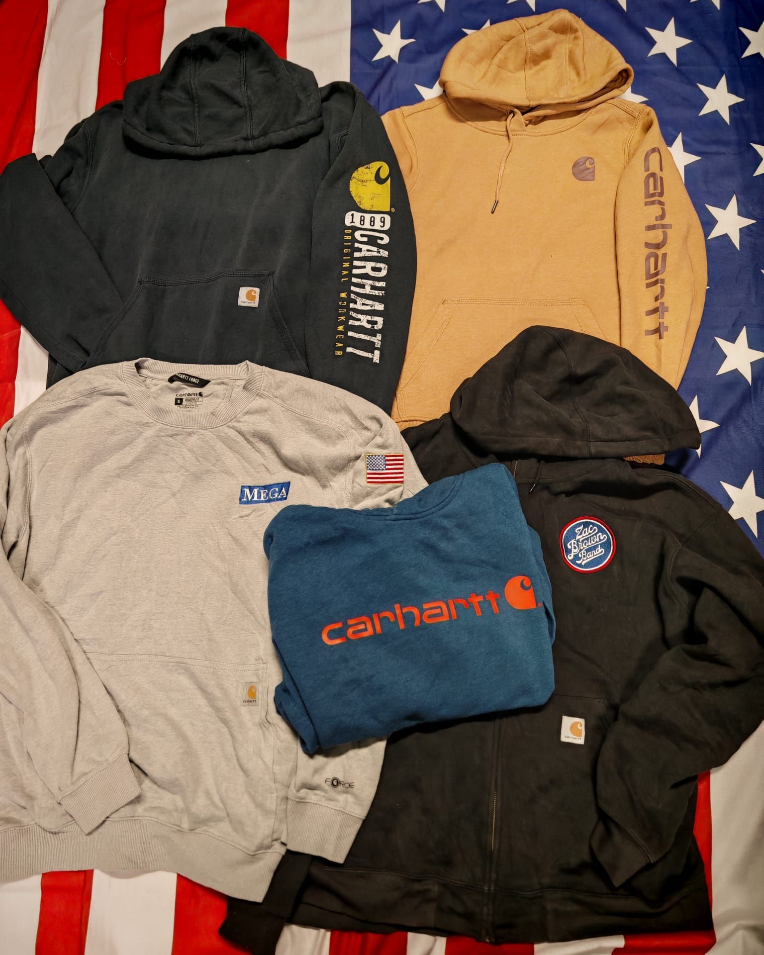 Cinque felpe con cappuccio nere, beige, grigie, blu e nere disposte su uno sfondo con la bandiera americana.