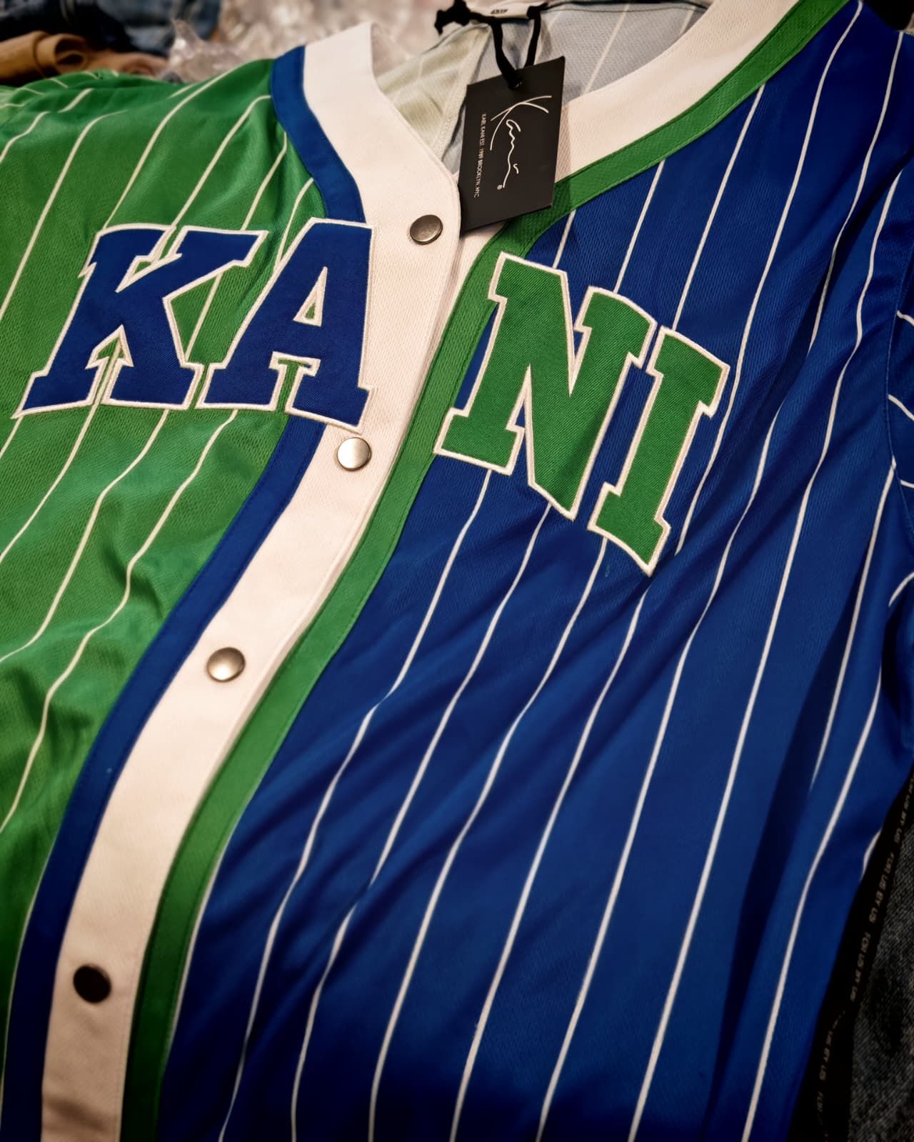 Maglia da baseball a righe blu e verdi con finiture bianche e la scritta