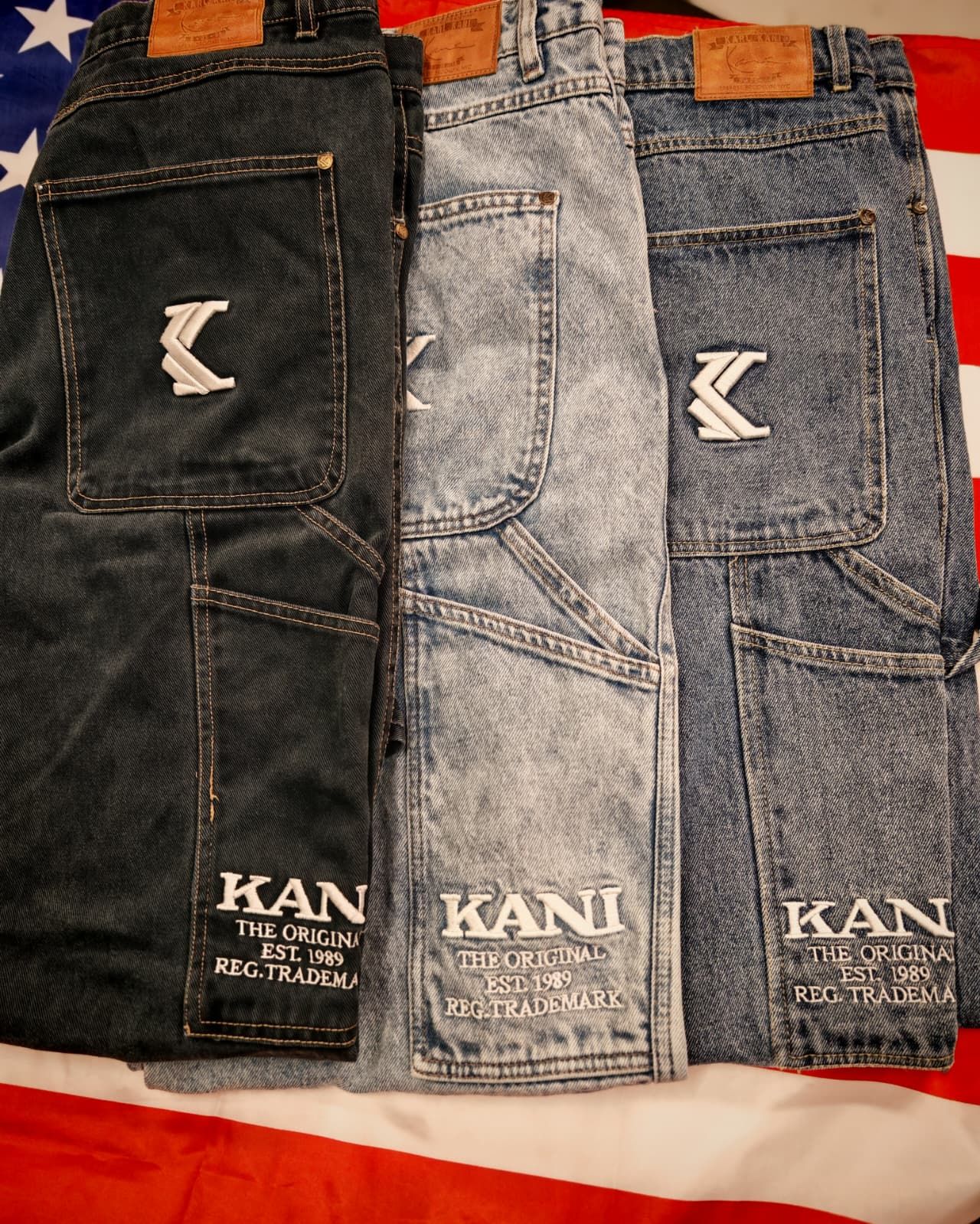 Tre paia di jeans KANI affiancati, nei colori nero, azzurro e blu.