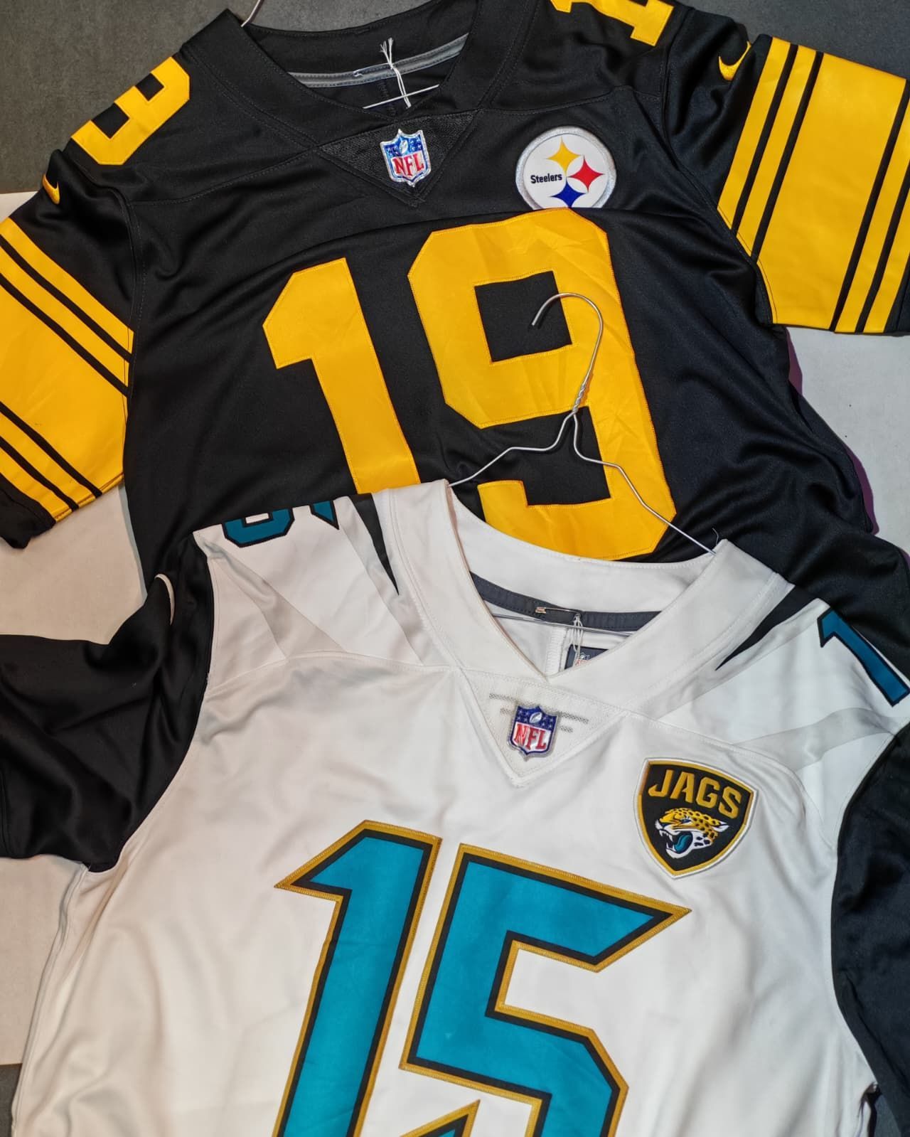 Due maglie da football americano stese una nera degli Steelers numero 19 e una bianca dei Jaguars numero 15.