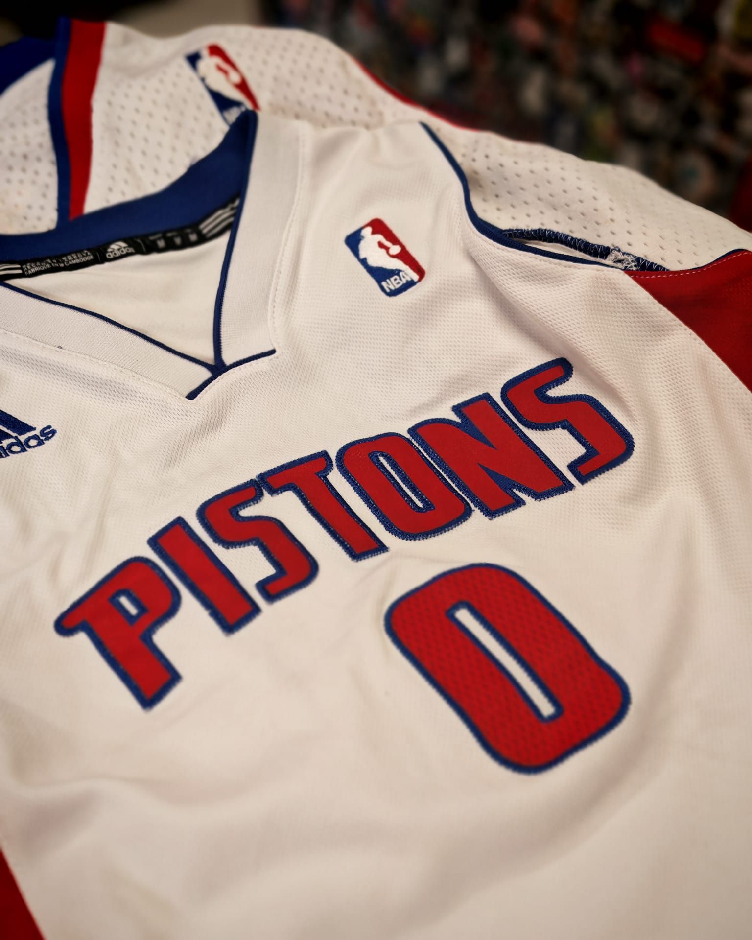Maglia da basket dei Detroit Pistons con il numero 0, bianca con finiture rosse e blu.