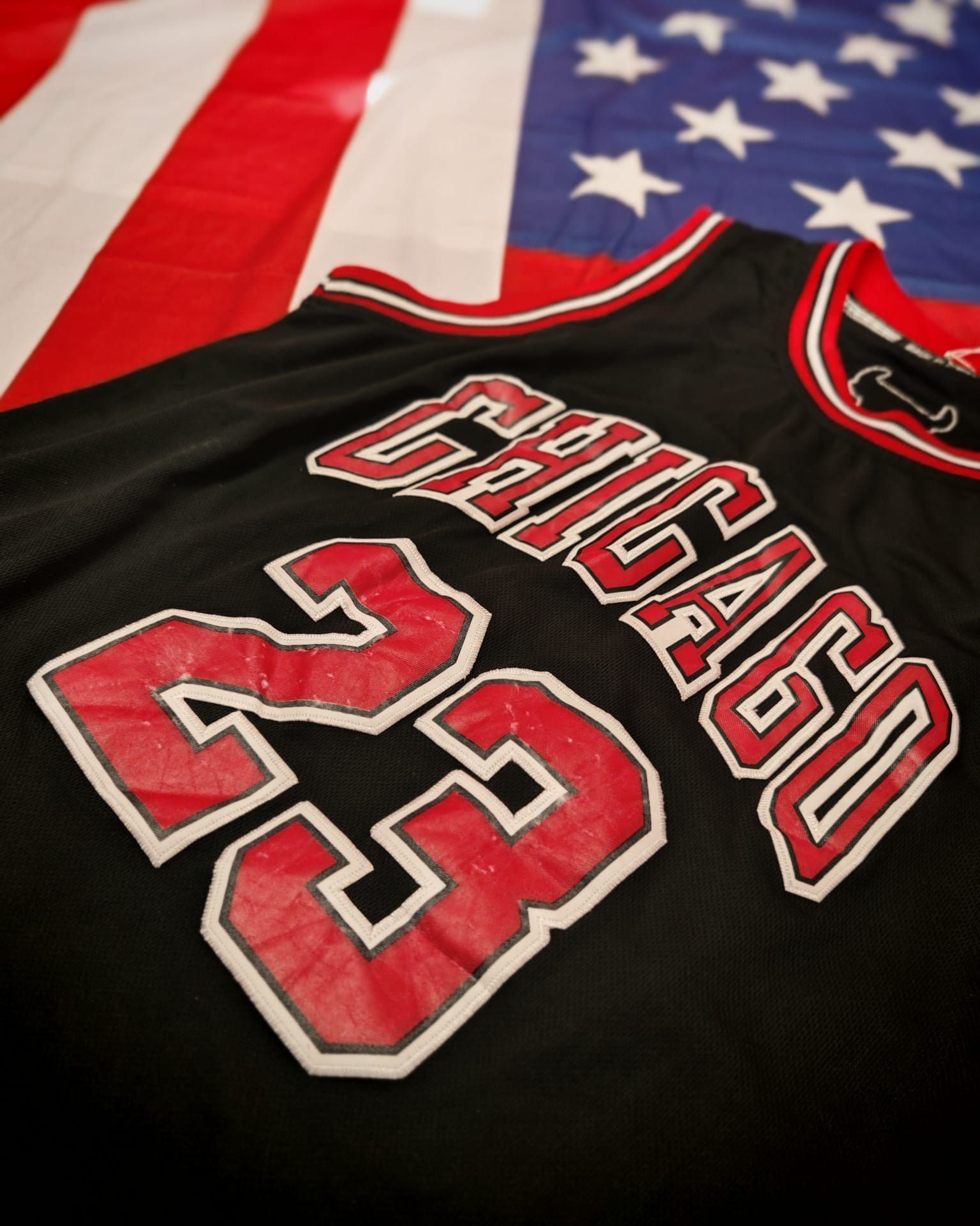 Maglia dei Chicago Bulls con il numero 23 su sfondo con la bandiera americana.