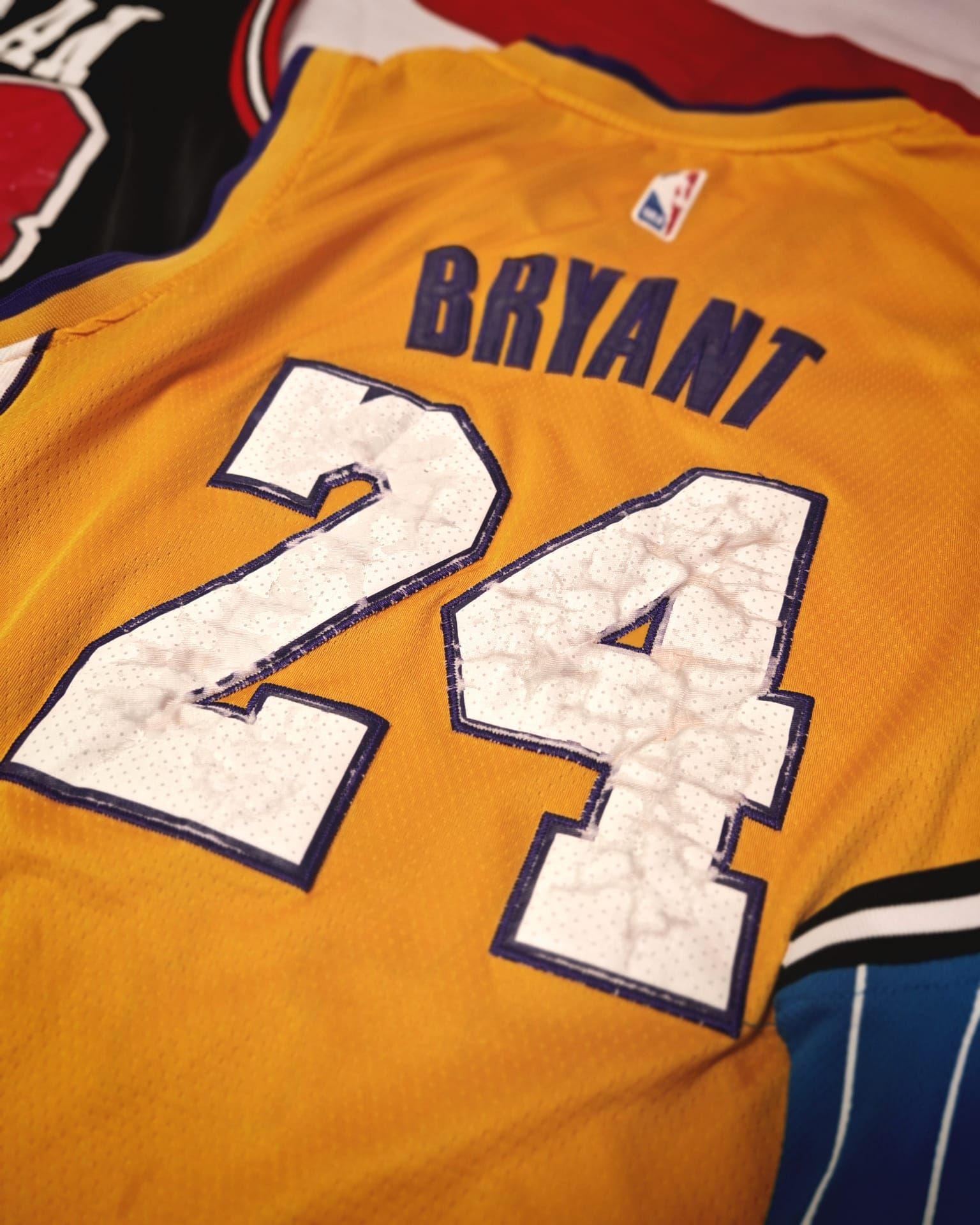 Maglia gialla dei Lakers di Kobe Bryant, numero 24, stesa su un letto.
