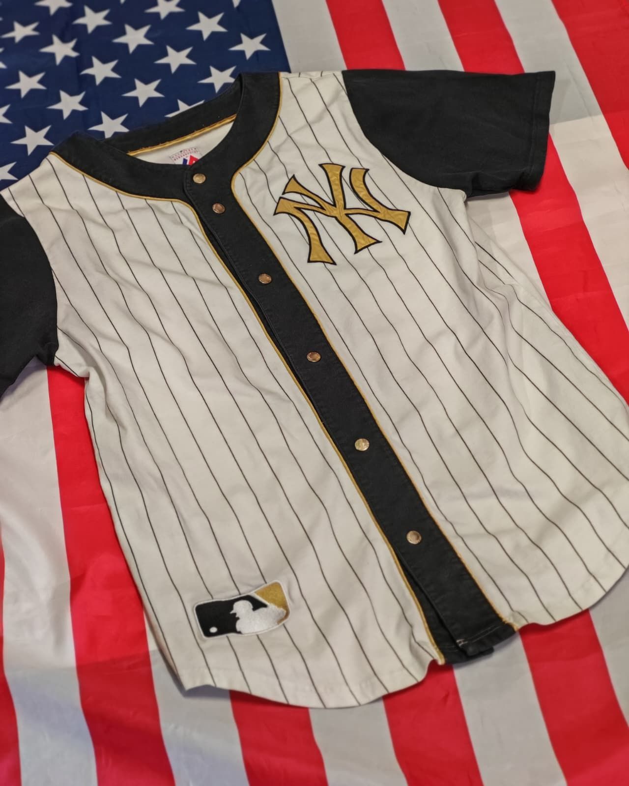 Maglia a righe dei New York Yankees sovrapposta a uno sfondo con la bandiera americana.