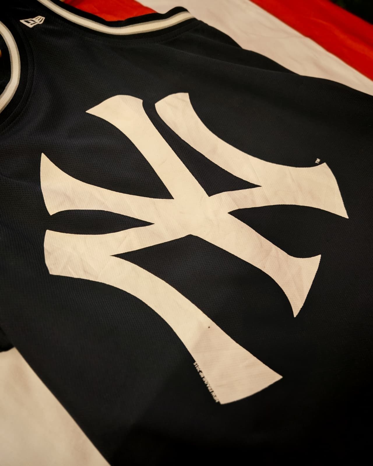 Primo piano di una maglia sportiva nera con un grande logo bianco dei New York Yankees.