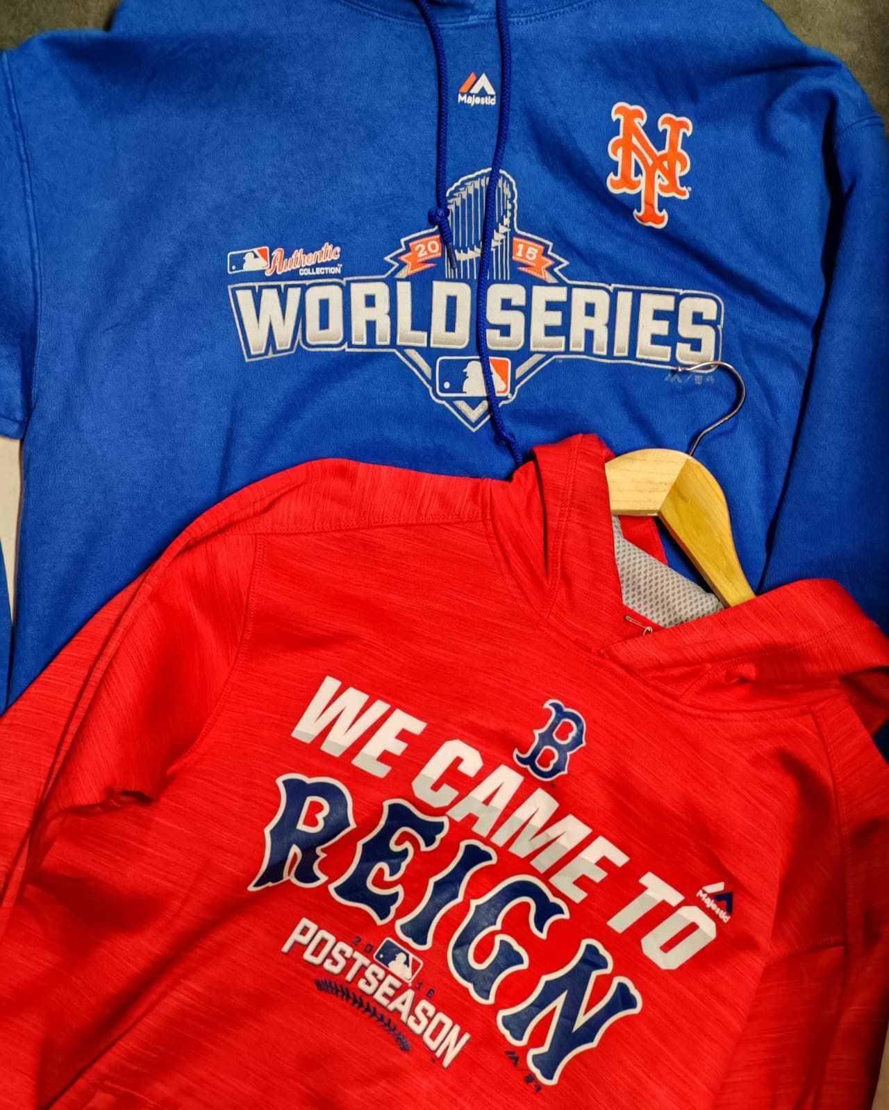 Due magliette da baseball: una felpa blu con cappuccio dei Mets per la World Series e una maglietta rossa dei Red Sox per i playoff.