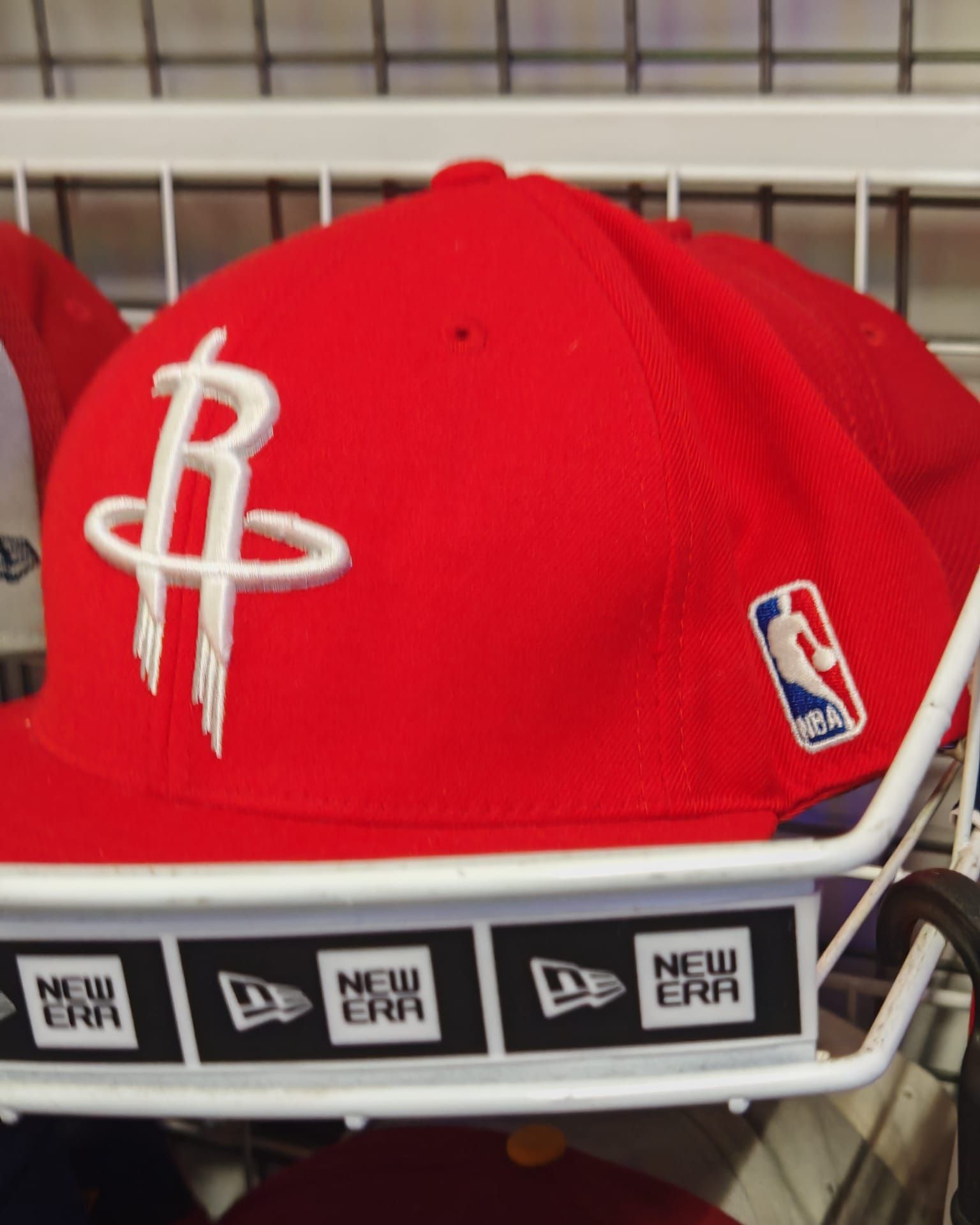 Cappellino rosso degli Houston Rockets su un espositore New Era con patch del logo NBA.