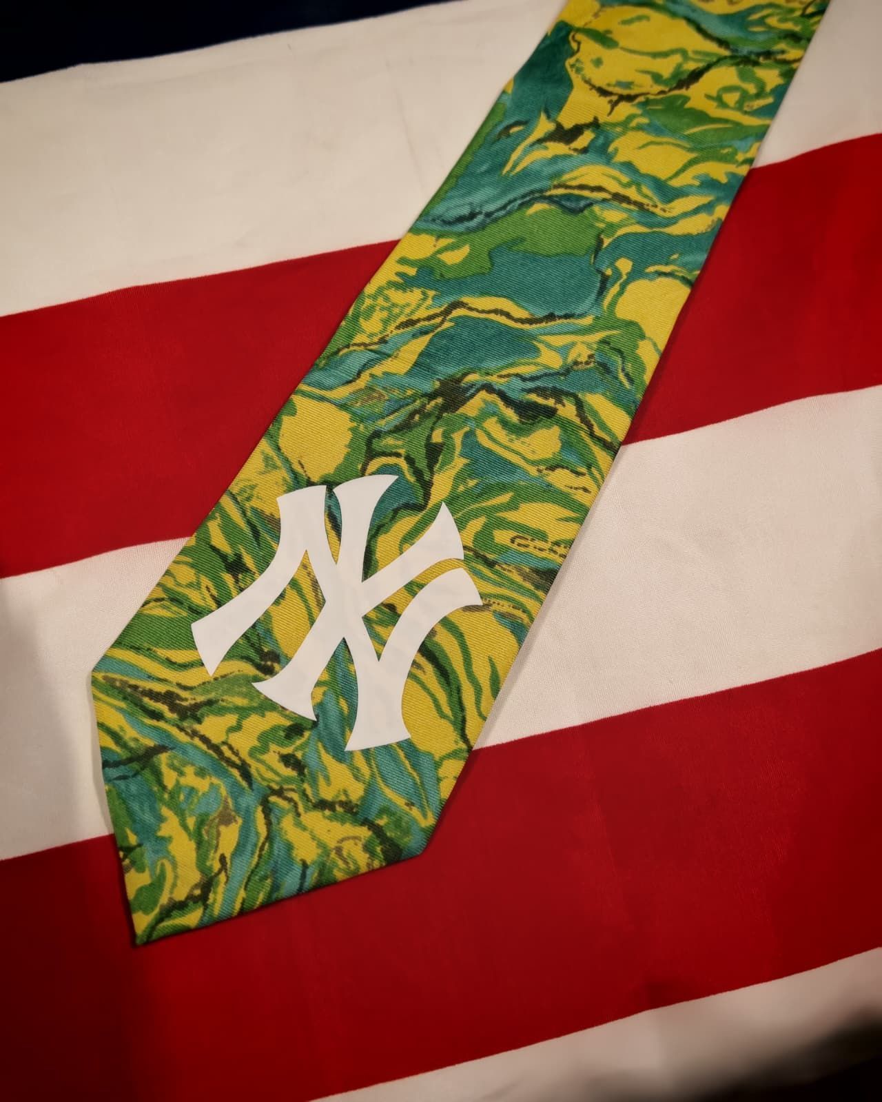 Cravatta dei New York Yankees con motivo verde su sfondo a righe rosse e bianche.