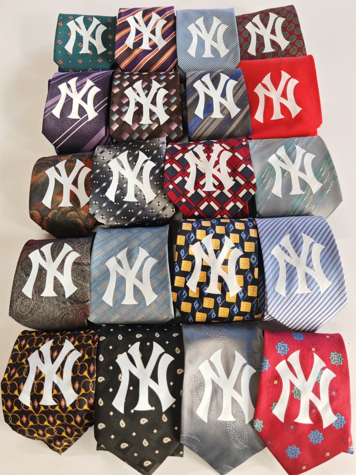 Pila di cappellini dei New York Yankees di vari colori e modelli, disposti a griglia