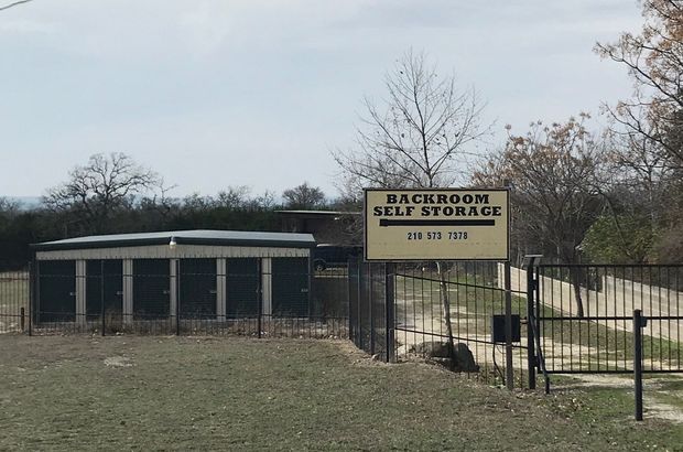 A row of storage units with yellow doors on a cloudy day.