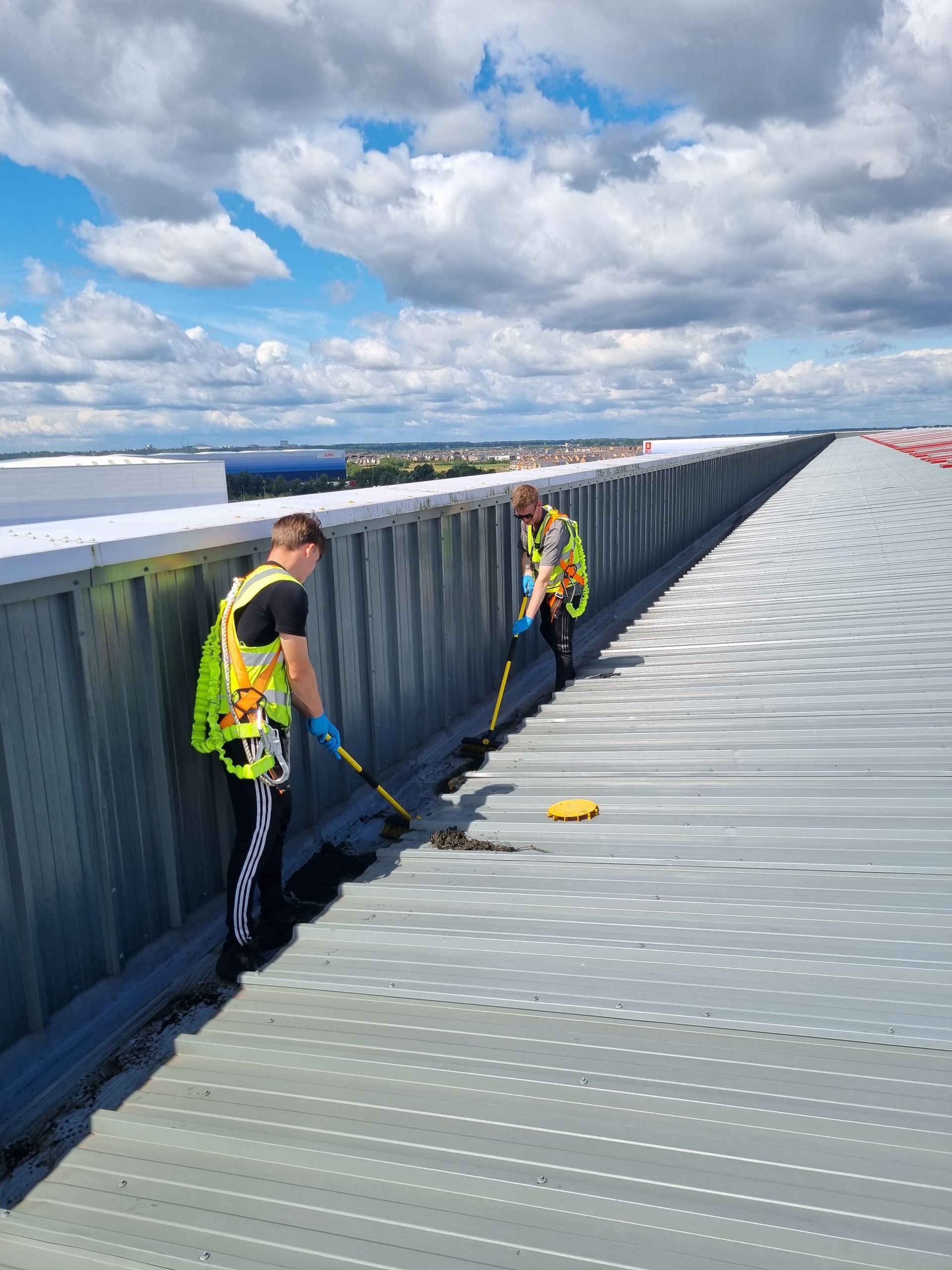 Two men are working on the roof of a building.