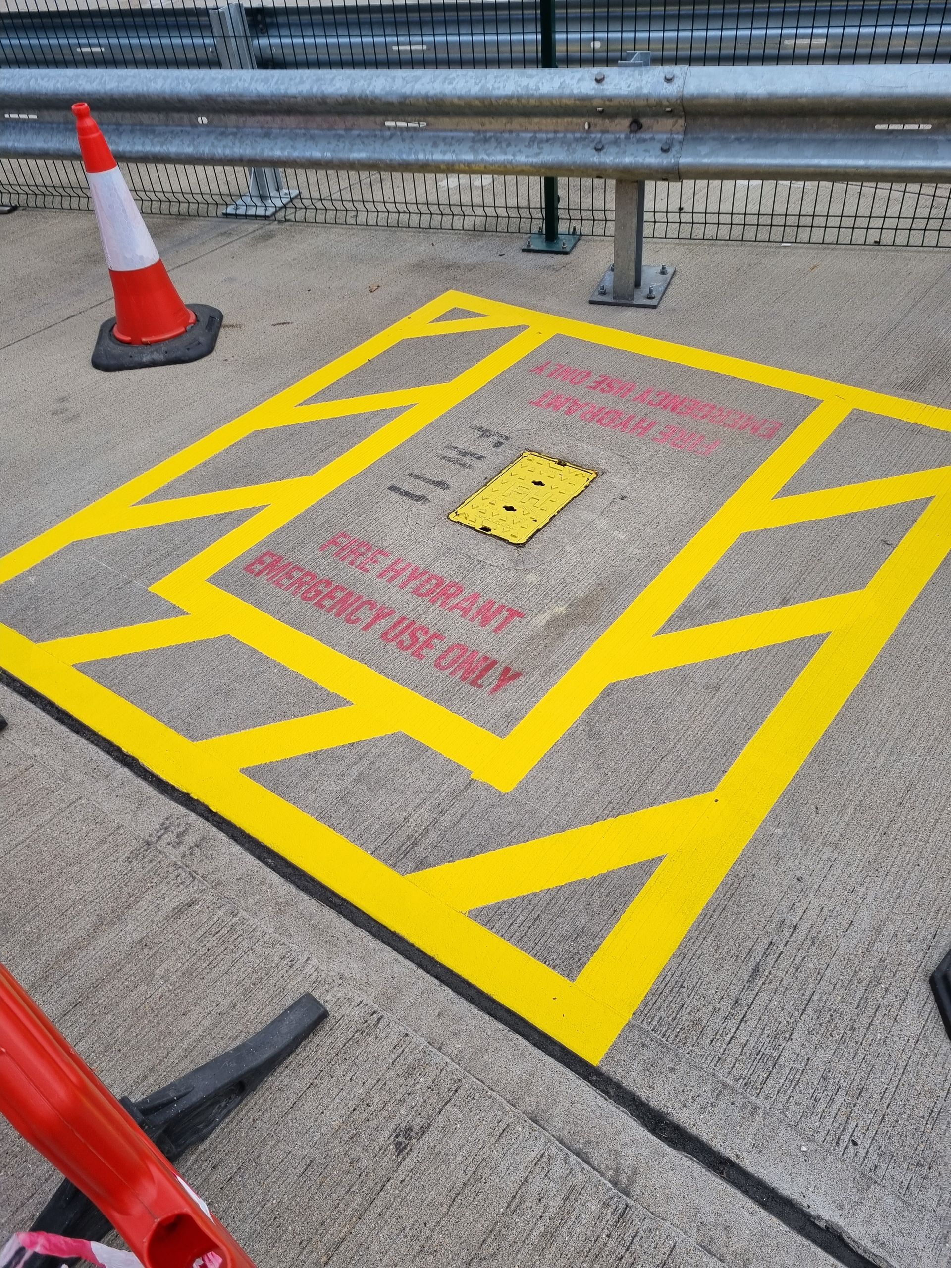 A yellow line on the ground that says do not enter